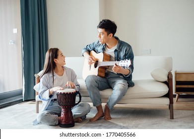 Young couple playing instruments at home - Powered by Shutterstock