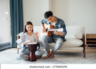 Young couple playing instruments at home - Powered by Shutterstock