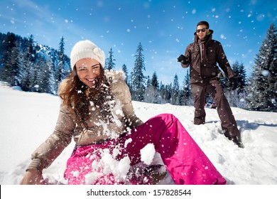 Young couple playing in snow, having snowball fight - Powered by Shutterstock