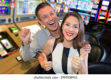 Young Couple Playing Together At Slot Machine