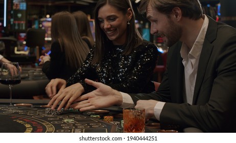 A Young Couple Plays Blackjack In An Elite Casino. The Players Are Happy And Celebrating A Card Win. Gambling, Nightlife