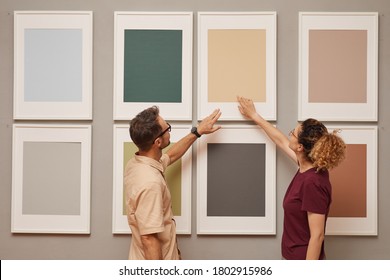 Young Couple Pointing At Picture Hanging On The Wall While They Visiting Art Gallery