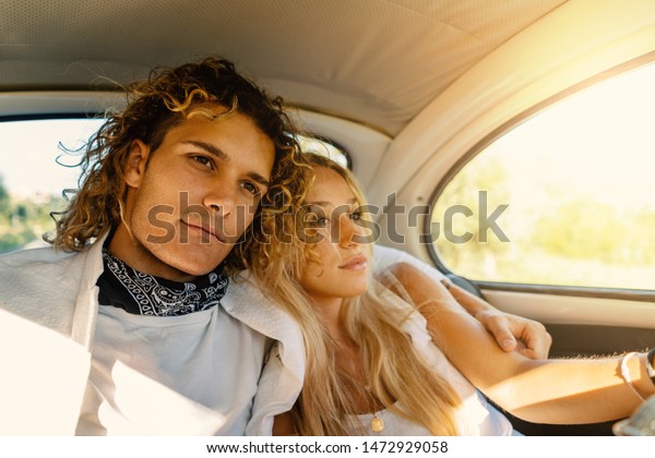 Young couple portrait inside vintage car with\
flare. Romantic lifestyle real\
image.
