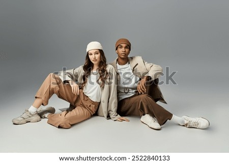 A young couple poses artfully, donning chic autumn outfits, exuding vibrant style.
