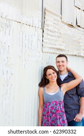 A Young Couple Poses For Some Engagement Photos In Urban Outdoor Settings.