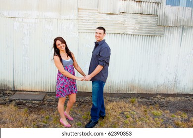 A Young Couple Poses For Some Engagement Photos In Urban Outdoor Settings.