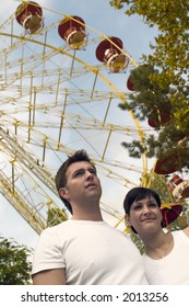 Young Couple Is Posing In The Theme Park.