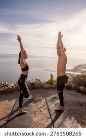 Young couple practices tree pose on a mountain ridge at sunset, finding balance, strength and mindfulness while overlooking a serene coastal landscape of Croatia and sea horizon