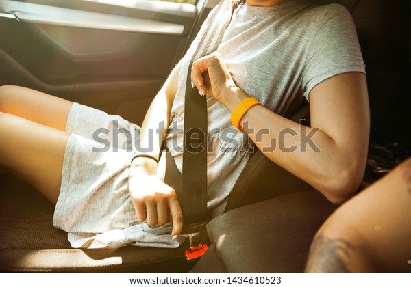 Young couple preparing for vacation trip on the\
car in sunny day. Woman and man sitting and ready for going to sea,\
riverside or ocean. Concept of relationship, vacation, summer,\
holiday, weekend.
