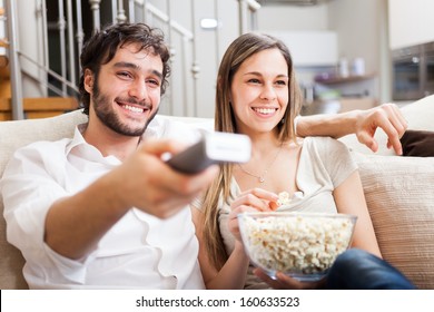 Young couple preparing to watch a movie