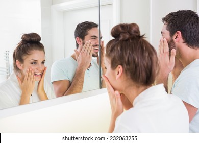 Young Couple Putting On Face Cream At Home In The Bathroom