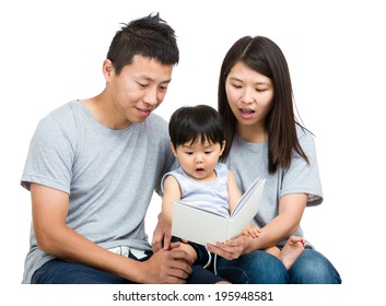 Young Couple Reading Book With Baby Boy