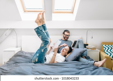 Young Couple Reading A Book In Bed 