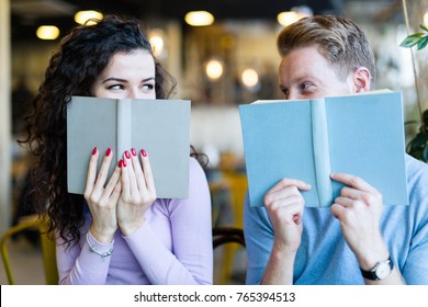 Young Couple Reading Books In Coffee Shop