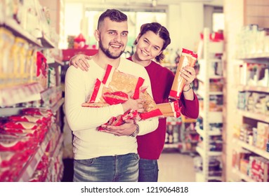 Young Couple Reading Lable Of Pasta At Supermarket