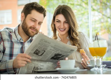 A Young Couple Reading The Newspaper