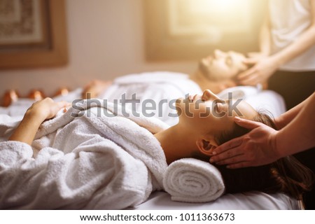 Young couple receiving head massage at beauty spa