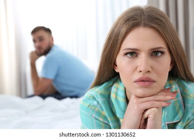 Young couple with relationship problems ignoring each other in bedroom