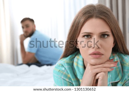 Young couple with relationship problems ignoring each other in bedroom