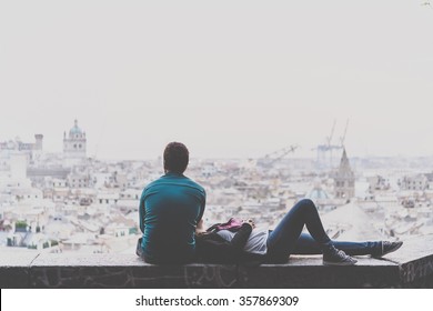 Young Couple Is Relaxing And Enjoying The View Of The City. Toned Picture