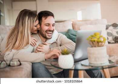 Young couple relaxing on sofa with laptop.Love,happiness,people and fun concept.
