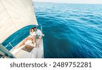 Young couple relaxing on yacht cruise - Two lovers enjoying summer vacation experience on sail boat at the sea - Summertime holidays and luxury travel concept