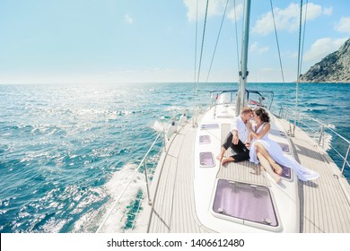 Young Couple Relaxing On A Yacht. Happy Wealthy Man And A Woman By Private Boat Have Sea Trip