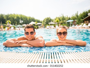 Young couple relaxing in resort swimming pool. - Powered by Shutterstock