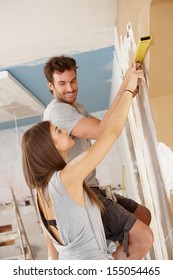 Young Couple Renewing House, Measuring, DIY.