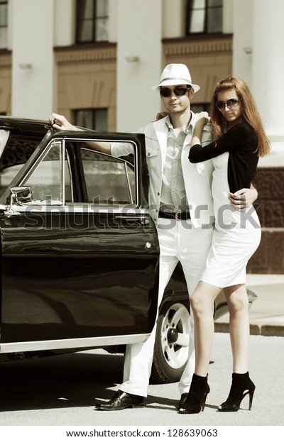 Young couple\
with retro car on the city\
street