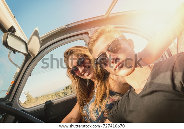 Young\
couple in a retro car  at sunset, retro\
style.