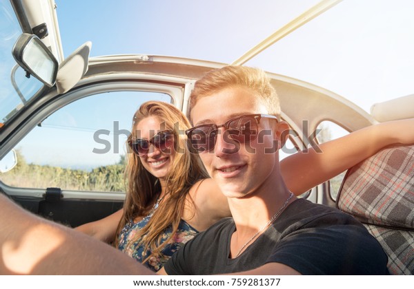 Young\
couple in a retro car  at sunset, retro\
style.