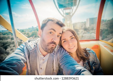 Young Couple Riding A Ferris Wheel On A Sunny Summer Day