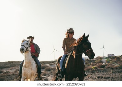 Young Couple Riding Horses Doing Excursion At Sunset - Soft Focus On Left Horse Face.