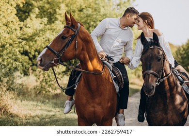 Young couple riding horses together in park - Powered by Shutterstock