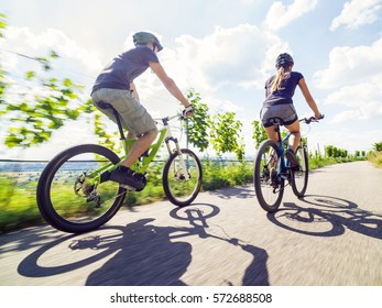 Young Couple Riding Their Mountain Bikes In The Summer.