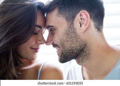 Young couple romancing in bedroom at home