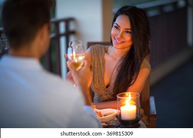 young couple with a romantic dinner with candles on tropical balcony 