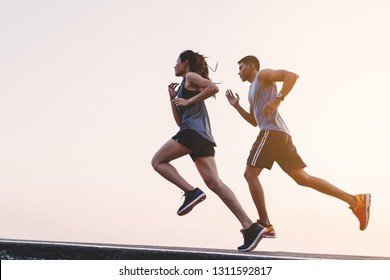 young couple runner running on running road in city park - Shutterstock ID 1311592817
