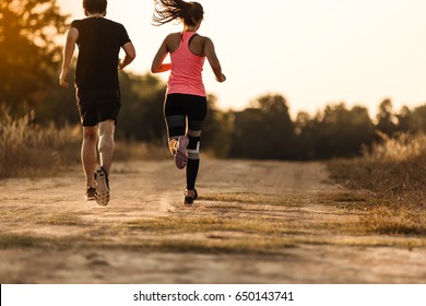 Young couple running at forest trail. stretching before fitness training session at the park. Healthy young warming up outdoors,hi key. - Powered by Shutterstock