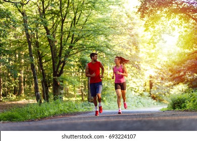 Young Couple Running In Nature.