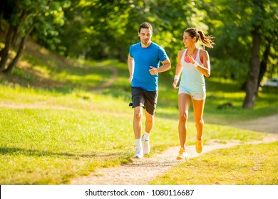 Young couple running in the park on the sunny day - Shutterstock ID 1080116687