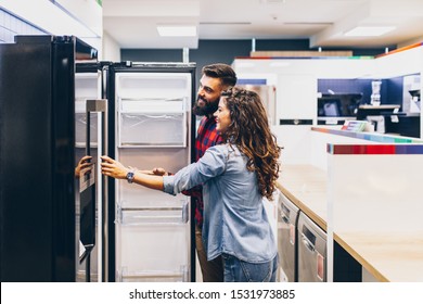 Young couple, satisfied customers choosing fridges in appliances store. - Shutterstock ID 1531973885