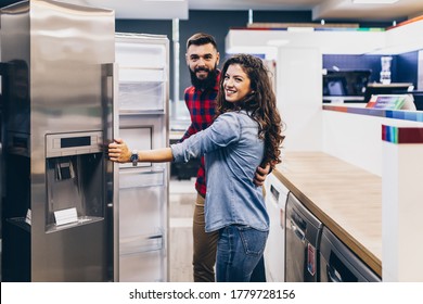 Young couple, satisfied customers choosing fridge in appliances store. - Shutterstock ID 1779728156
