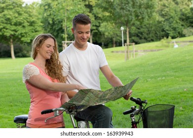 A young couple is searching the direction during a bicycle tour