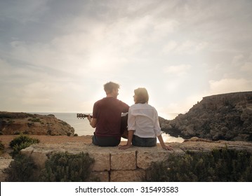 Young couple at the seaside playing guitar - Powered by Shutterstock