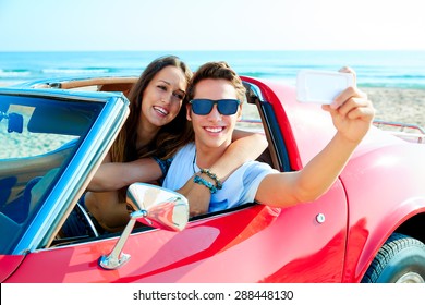 Young Couple Selfie Happy In A Red Convertible Car At The Beach