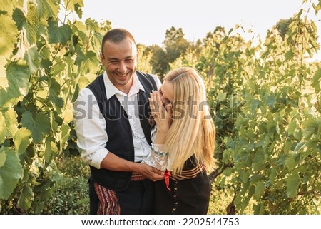 Young couple in a Serbian traditional clothes in the vineyard