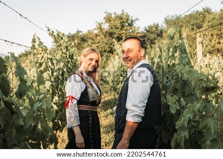 Young couple in a Serbian traditional clothes in the vineyard