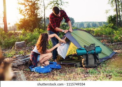 Young couple setting up tent outdoors,hiking and camping - Powered by Shutterstock